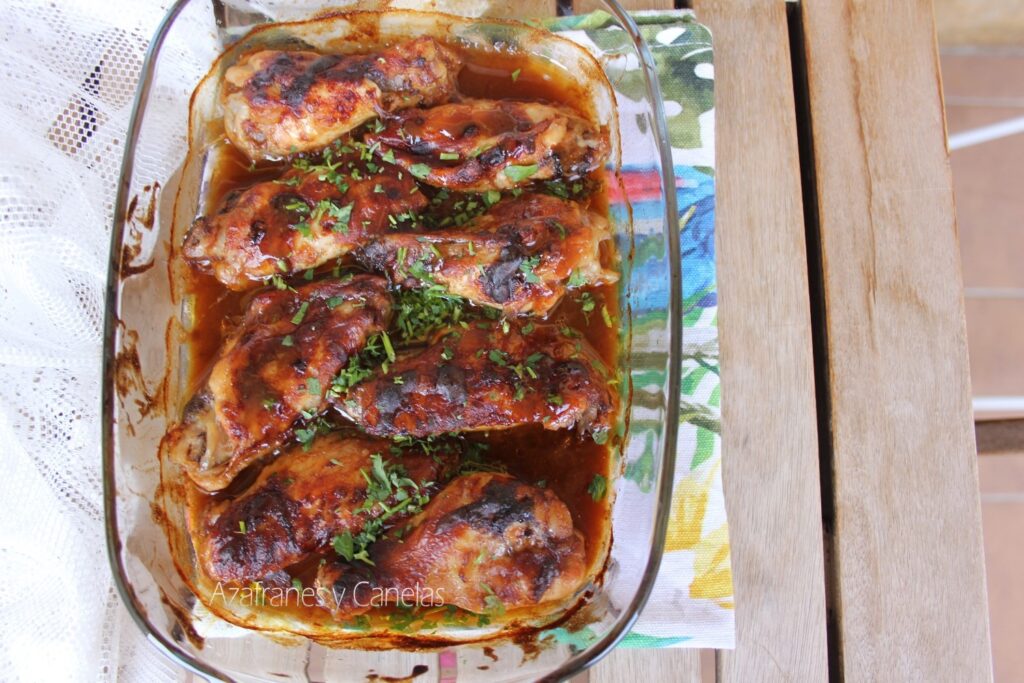 Alitas de pollo barbacoa. Bandeja de horno con alitas de pollo doradas cubiertas de perejil fresco picado.