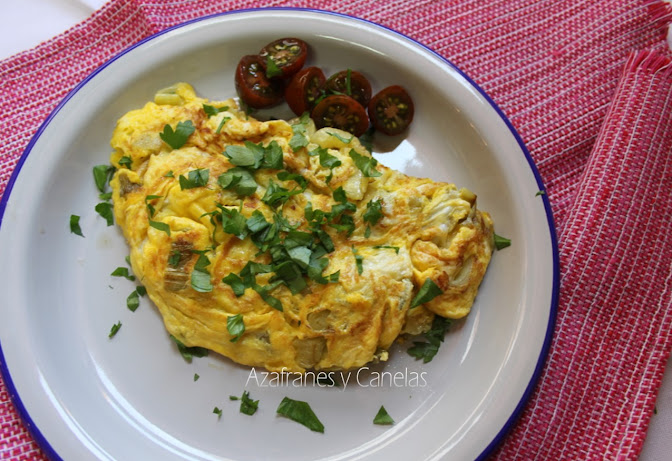 Tortilla de bacalao con patatas. en un plato de cerámica con tomates pequeños aliñados