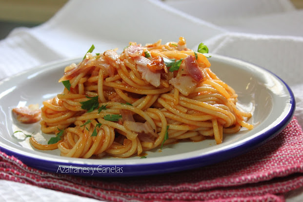 Espaguetis con bacon y tomate. Presentados sobre un palto de cerámica.