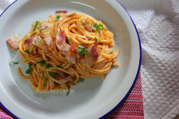 Espaguetis con bacon y tomate. Presentados sobre un palto de cerámica. Aun humean.